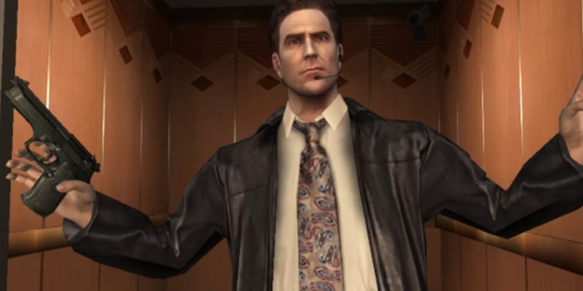 Max Payne lève les bras en signe de reddition, sa cravate emblématique, sa veste en cuir et sa chemise blanche clairement visibles.