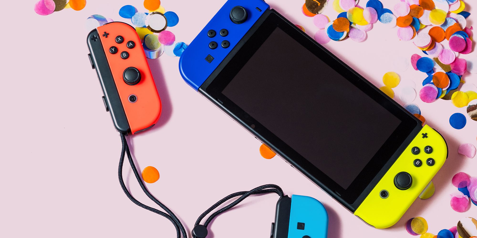 Nintendo Switch avec des Joy-Con bleus et jaunes à côté de Joy-Con rouges et bleus détachés